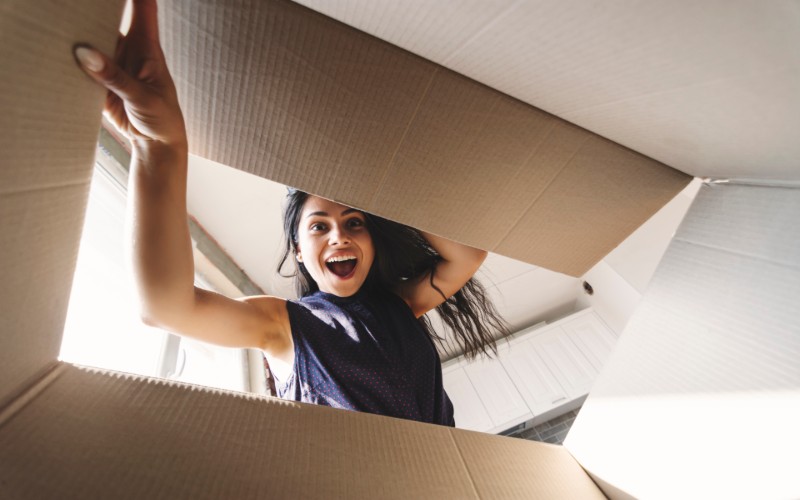 woman looking into cardboard box