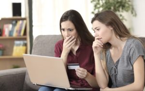 worried friends on sofa with laptop