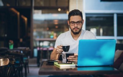 man working on laptop in coffee shop