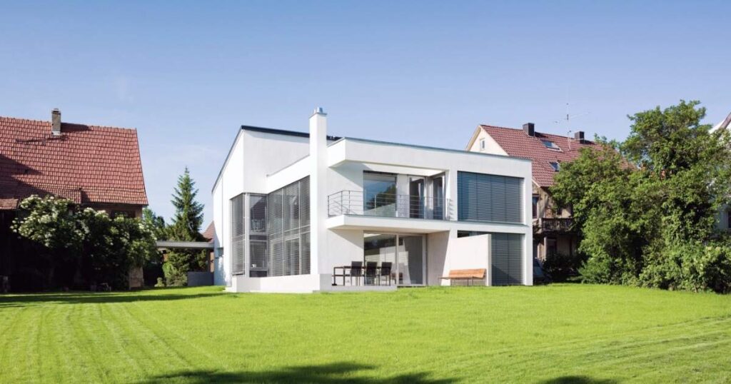 green home on summer meadow