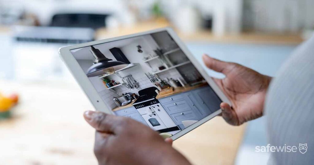 Woman watching the security cameras of her house using her tablet