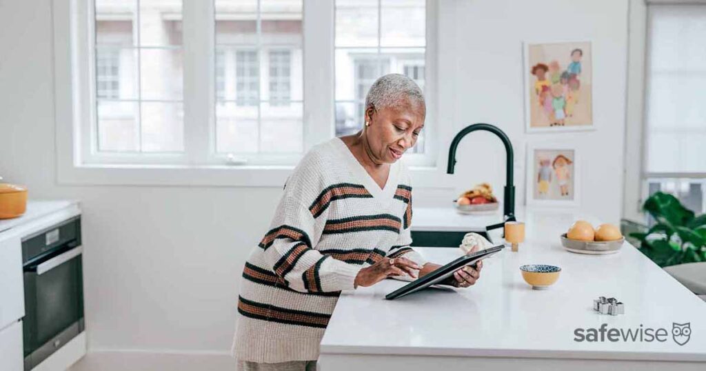 elderly-woman-stanging-at-counter-using-ipad