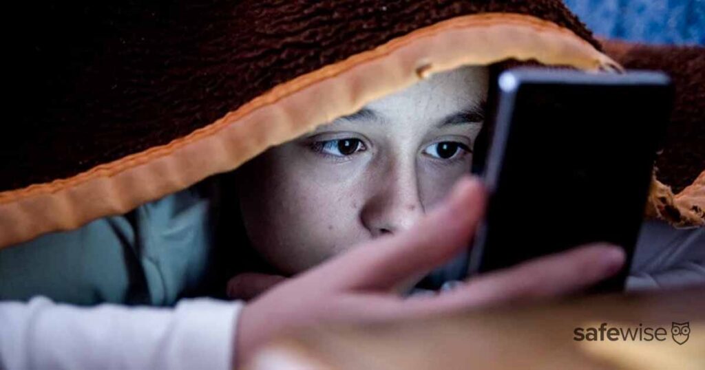 kid-looking-at-phone-under-blanket