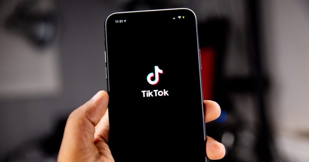 hand holding an iphone with the tiktok app loaded