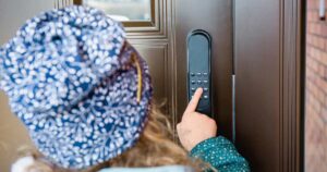 Girl child opening home smart door lock, unlocking the code.