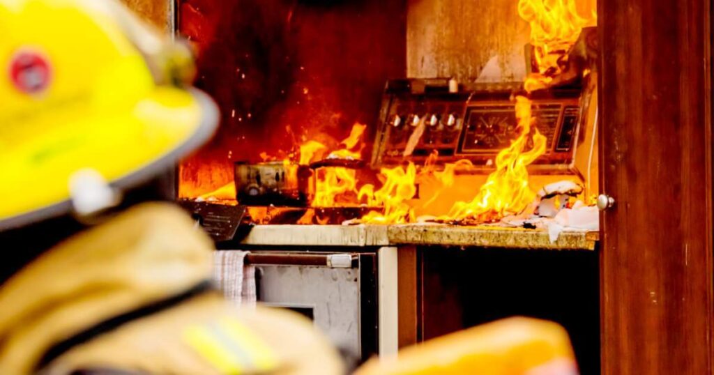 Firefighters and a stove fire. Firefighters in the foreground.