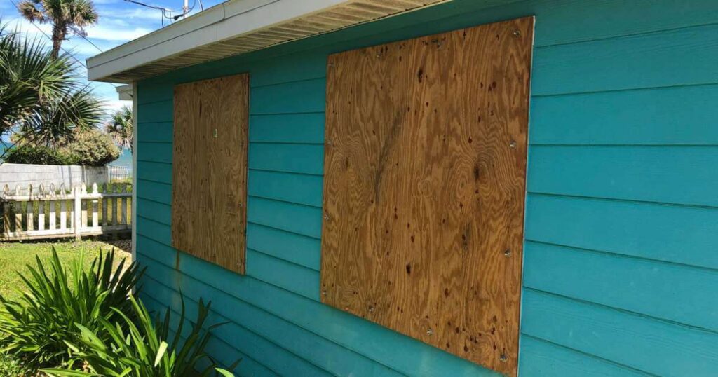 Homemade plywood covers the windows of a beach cottage in Florida in preparation for an oncoming hurricane.