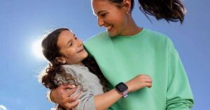 Mom and daughter hugging, smiling, with Garmin Bounce kids smartwatch on daughter's wrist.