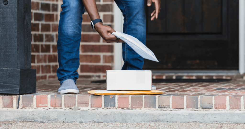 Man picks up delivery envelope on doorstep