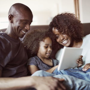 Happy parents looking at son using digital tablet
